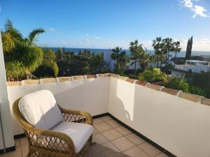 una silla de mimbre sentada en un balcón con vistas al océano en Sapore di mare Luxury B&B and Cooking, en Marbella