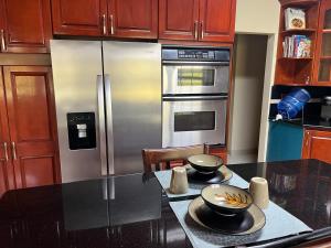 a kitchen with a stainless steel refrigerator and a table at Krizia Place in Nassau