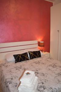 sypialnia z łóżkiem z czerwoną ścianą w obiekcie Villa Victoria, Taormina w Taominie