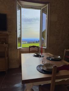 una mesa con vistas al océano desde una ventana en Élégance et Charme au Cœur des Vignes - Piscine et Décoration Artisanale en Le Pian-sur-Garonne
