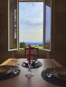 une table avec une bougie sur une table et une fenêtre dans l'établissement Élégance et Charme au Cœur des Vignes - Piscine et Décoration Artisanale, à Le Pian-sur-Garonne