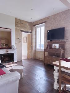 sala de estar con chimenea y TV en Élégance et Charme au Cœur des Vignes - Piscine et Décoration Artisanale en Le Pian-sur-Garonne