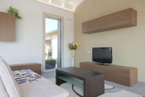 sala de estar con TV y sofá en Case VR Holiday ResiRenza en Verona