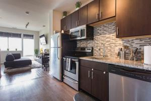 a kitchen with stainless steel appliances and a living room at Quaint Studio w/Pool Table/Patio by Italian Market in Philadelphia