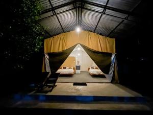 a tent with two beds inside of it at night at Glampin By Tharu Garden in Sauraha