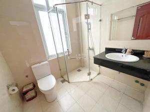 a bathroom with a shower and a toilet and a sink at Sunny Motel Tuần Châu in Ha Long