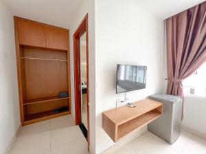 a small room with a toilet and a television at Sunny Motel Tuần Châu in Ha Long
