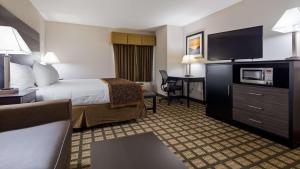 um quarto de hotel com uma cama e uma televisão de ecrã plano em Best Western Beacon Inn em Grand Haven