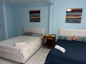 a bedroom with two beds and a night stand with a bedskirts at 3BR, 1BA Spacious Property in Cataño, Near Bacardí in Catano