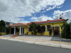 uma casa amarela com um telhado vermelho numa rua em 3BR, 1BA Spacious Property in Cataño, Near Bacardí em Catano