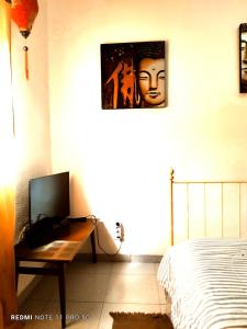 a bedroom with a bed and a desk with a television at Casapatrizia Appartamento compartido in Santa Cruz de Tenerife