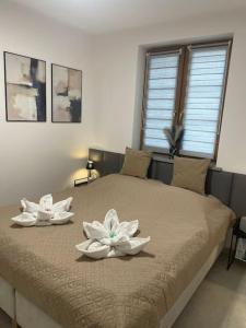 twee witte bloemen op een bed in een slaapkamer bij The Terrace — Karpacz in Karpacz