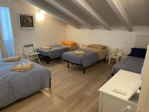 a room with four beds and a table and chairs at B&B il giardino dello Yogi in Savio di Ravenna