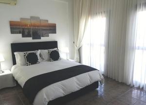 um quarto com uma cama grande e 2 janelas em Stunning Private Villa - Beautiful Gardens & Pool em Lapithos