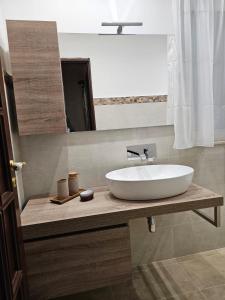 La salle de bains est pourvue d'un lavabo blanc et d'un miroir. dans l'établissement Casa Maya, à Brucoli