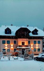 ein großes Gebäude mit Schnee darüber in der Unterkunft Ferienwohnungen Seerose in Dellach direkt am Millstätter See in Millstatt