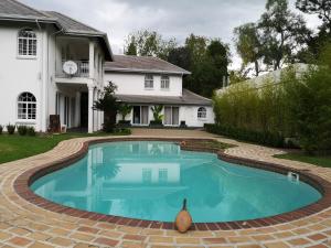 una piscina nel cortile di una casa di Lotus Guest House a Johannesburg