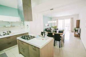 eine Küche und ein Wohnzimmer mit einem Herd mit Backofen in der Unterkunft Duplex Apartment With Sharing Pool- Mellieha in Mellieħa