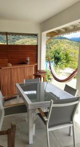 einen Tisch und Stühle in einem Zimmer mit Hängematte in der Unterkunft Magnifique vue mer sur baie de Malendure in Bouillante