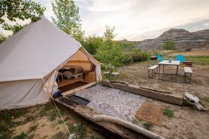 uma tenda com uma mesa e cadeiras num campo em #7 Whole New World em Drumheller