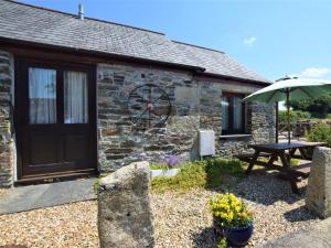 a stone cottage with a picnic table and an umbrella at 2 Bed in Liskeard CONGS in North Hill