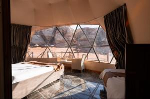 Pokój z 2 łóżkami i dużym oknem w obiekcie experience staying camp.wadi rum w mieście Disah