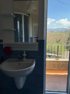 un bagno con lavandino e specchio e un balcone di LA TERRAZZA SU ROMA a Zagarolo
