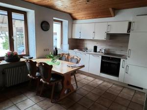 托特瑙的住宿－Ferienwohnung im Todtnauer Ferienland，厨房配有木桌和椅子