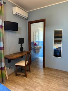 een kamer met een bureau, een bed en een badkamer bij LA TERRAZZA SU ROMA in Zagarolo