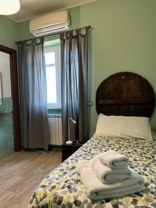 una camera da letto con un letto e asciugamani di LA TERRAZZA SU ROMA a Zagarolo