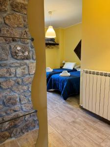 a bedroom with a bed and a stone wall at LA TERRAZZA SU ROMA in Zagarolo
