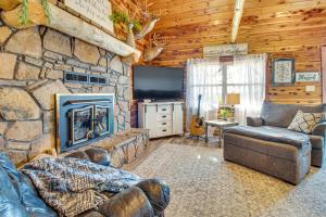 sala de estar con chimenea de piedra y TV en Expansive Mountain Home Rental with Yard and Fire Pit!, en Mountain Home