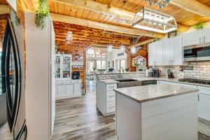 una cocina con armarios blancos y techos de madera. en Expansive Mountain Home Rental with Yard and Fire Pit!, en Mountain Home