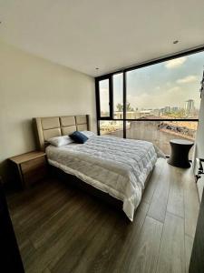 a bedroom with a bed and a large window at Metropolitan Blue SK in Guatemala