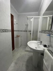 a white bathroom with a sink and a shower at Apartamento Castiñeira in Fisterra +10 photos