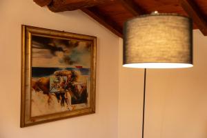 une lampe et une photo sur un mur avec une peinture dans l'établissement Suite Carlo - Modena, à Casinalbo