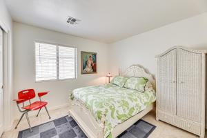 1 dormitorio con 1 cama y 1 silla roja en Coolidge Home with Patio, Near Casa Grande Monument!, en Coolidge