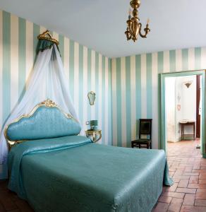 1 dormitorio con 1 cama azul con dosel en AGRITURISMO CASTELLO BECCARIA, en Pieve del Cairo