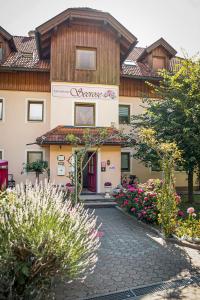 a building with a courtyard with flowers in front of it at Ferienwohnungen Seerose in Dellach direkt am Millstätter See in Millstatt