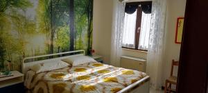 ein Schlafzimmer mit einem Bett und einem großen Fenster in der Unterkunft Casa Vacanze Bouganville in Calasetta
