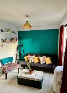 - un salon avec un canapé et un mur vert dans l'établissement Departamento Jose, à San Miguel de Tucumán