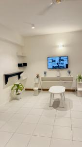 a white room with a table and a tv on the wall at The pontoons in Mombasa
