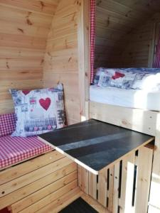 una habitación con 2 camas y un banco en una cabaña en Auszeit-Wohnfass im Grünen, 