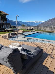 een bed op een terras naast een zwembad bij Hotel Sigmundskron in Appiano sulla Strada del Vino