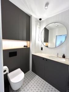 a bathroom with a toilet and a sink and a mirror at Apartament Lina Koralowa in Lublin