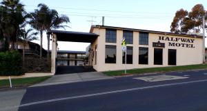 een gebouw met een hall way motel aan de kant van een straat bij Halfway Motel in Eden