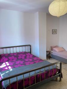 um quarto com uma cama com lençóis roxos em Chambres indépendantes en plein centre historique em Beaucaire