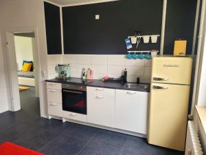 uma cozinha com um frigorífico amarelo e um lavatório em Get-your-flat - traumhaft niedliche FeWo 2 Zr Kü Bad, Haustier auf Anfrage, ruhig & stadtnah EG - TOP em Bochum