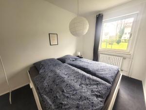 um quarto com uma cama e uma janela em Get-your-flat - traumhaft niedliche FeWo 2 Zr Kü Bad, Haustier auf Anfrage, ruhig & stadtnah EG - TOP em Bochum