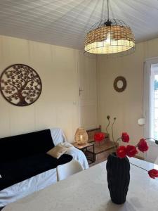 a living room with a table with red flowers on it at Casa Bretalunya in Benissanet